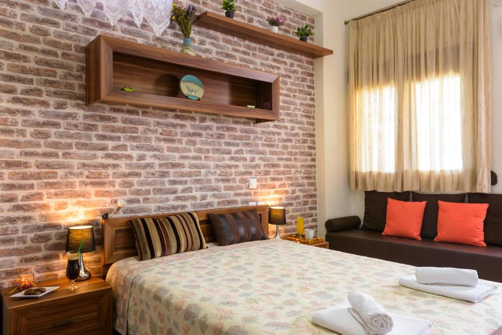 a bedroom with a bed and a brick wall at Seaside Studios in Milatos