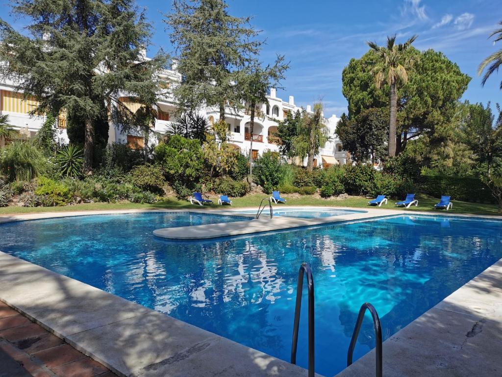 a swimming pool with blue water in a resort at Nueva Andalucia - Penthouse in Marbella