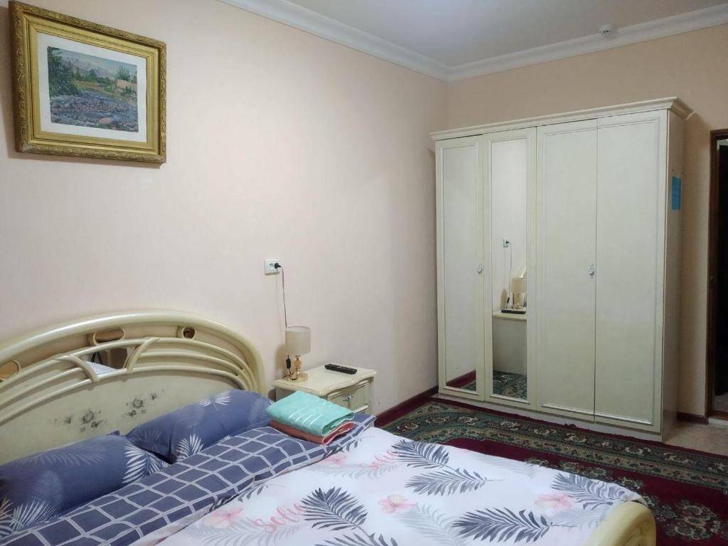 a bedroom with a bed with blue pillows at Samia House Room on Furkat 8 in Tashkent