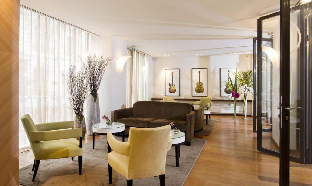 a living room with a couch and chairs at Hôtel Le Colisée in Paris