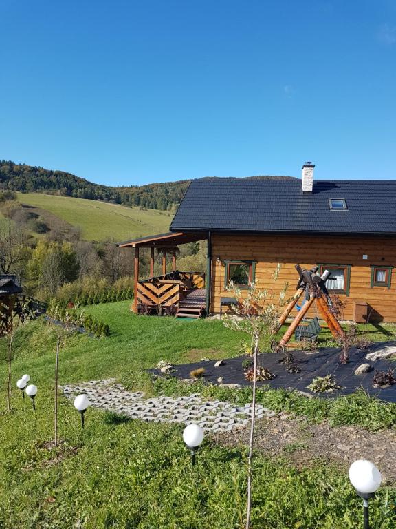 a log cabin with a windmill in front of it at Kiczurka Bieszczady in Baligród