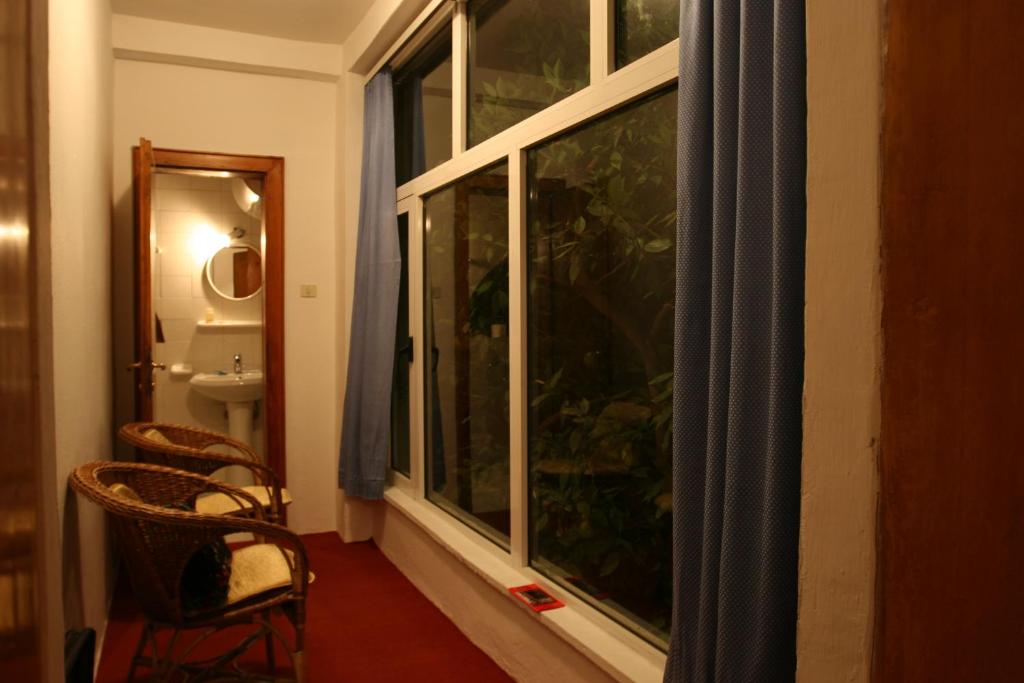 Habitación con ventana grande y baño. en Guesthouse Pension Andrea, en Tirana