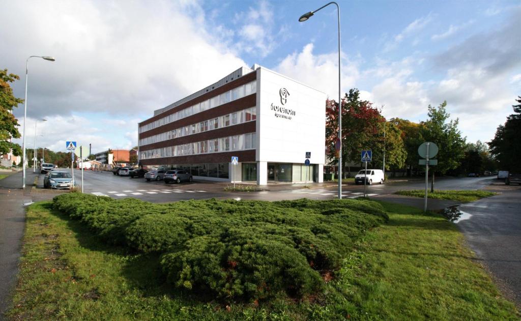 un grand bâtiment en face d'un parking dans l'établissement Forenom Serviced Apartments Rauma Kaivopuisto, à Rauma