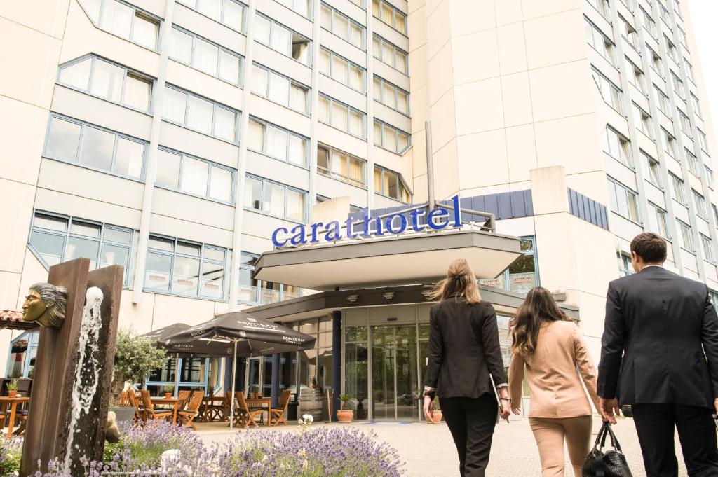 a group of people walking in front of a building at Carathotel Basel/Weil am Rhein in Weil am Rhein