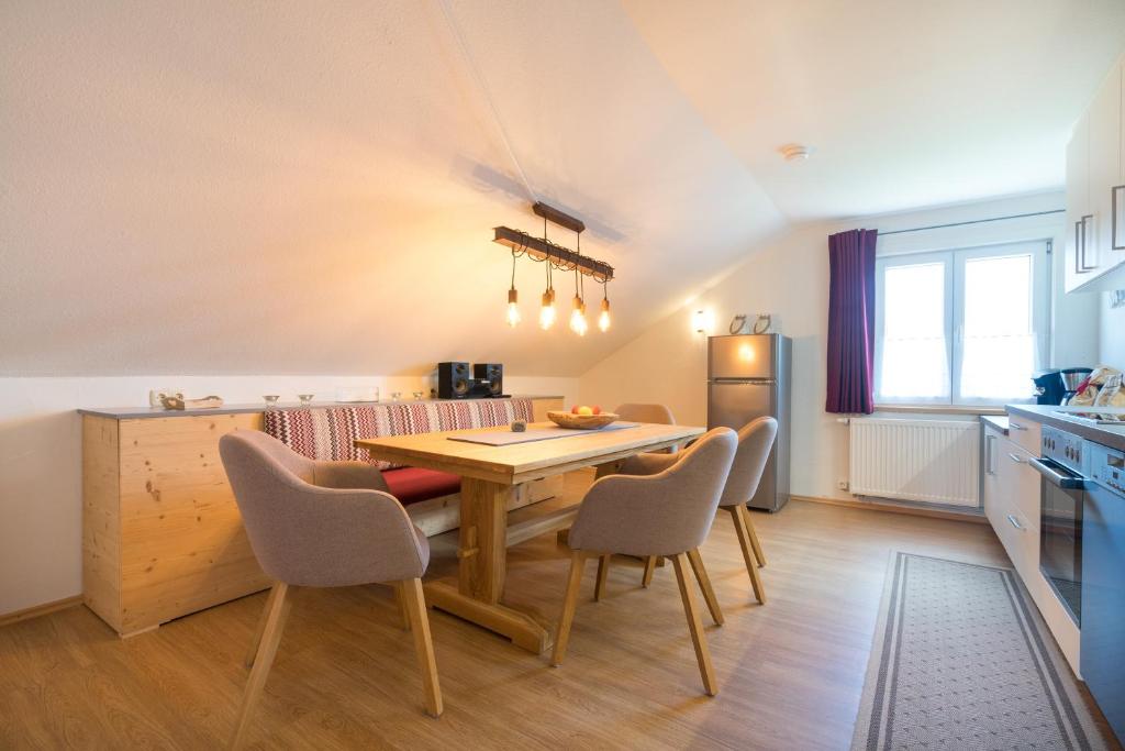 a kitchen and dining room with a wooden table and chairs at Ferienwohnungen Alpentraum - Gerstruben in Fischen