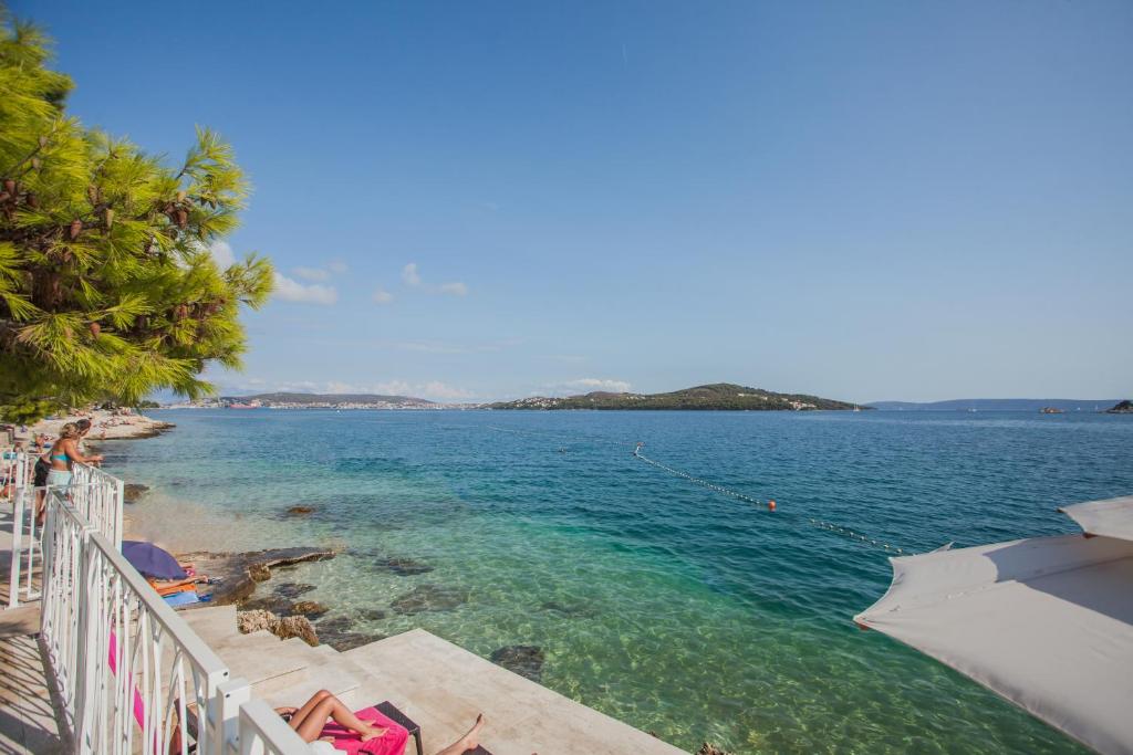 a view of the ocean from a beach with an umbrella at Happy Camp mobile homes in Camping Amadria Park Camping Trogir in Seget Vranjica