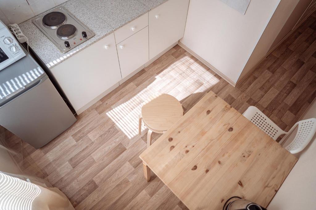 a small kitchen with a wooden table and chairs at Квартира Аэропорт Красноярск in Yemel'yanovo