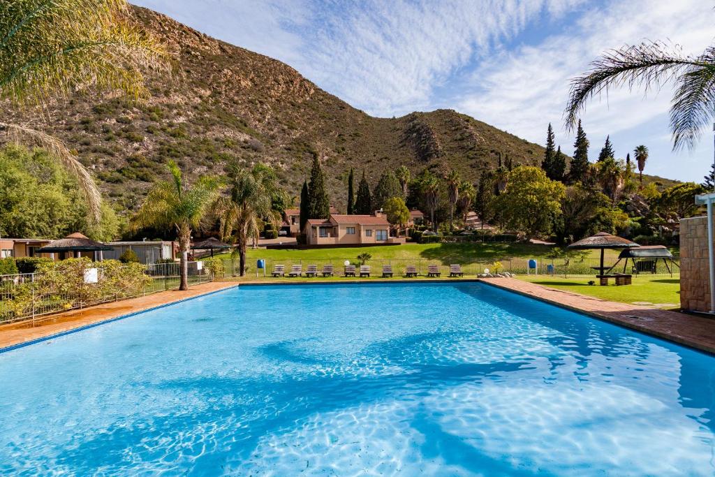 una gran piscina azul frente a una montaña en Montagu Springs Resort, en Montagu