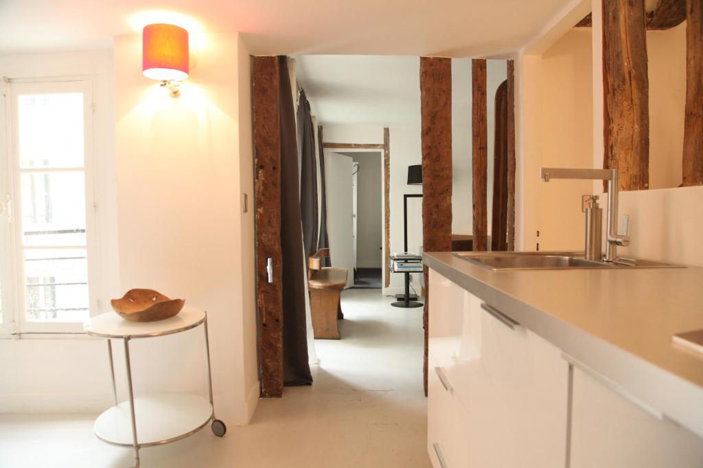 eine Küche mit einer Theke und einem Stuhl in einem Zimmer in der Unterkunft Bail mobilité appartement Louvre Palais Royal in Paris
