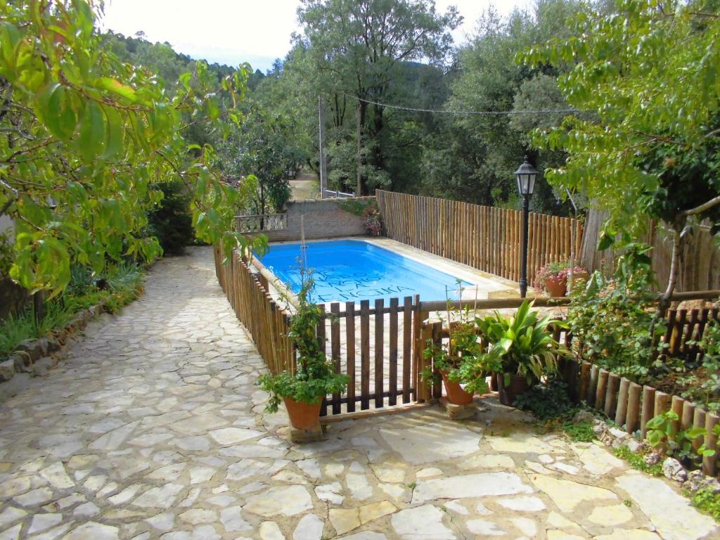 a swimming pool in a yard with a fence at Alojamientos Rurales Vado Ancho La Encina in Arroyo Frio