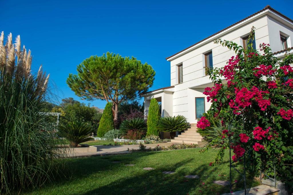 a white house with flowers in the yard at Villa Komfort in Zakynthos