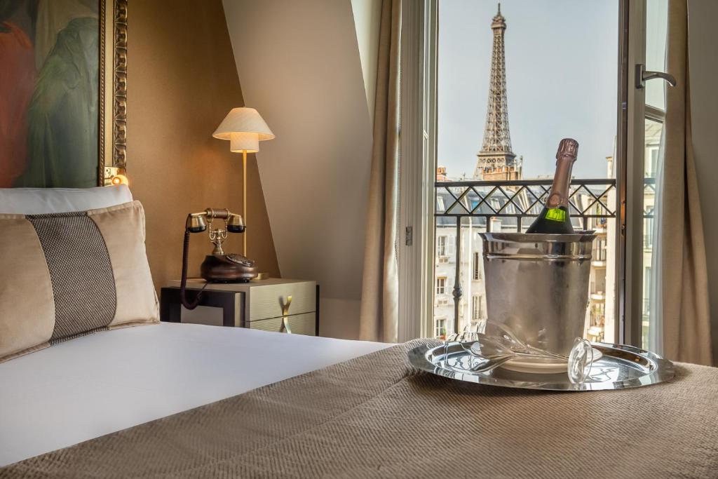a bedroom with a bed and a view of the eiffel tower at Hôtel Le Walt by Inwood Hotels in Paris