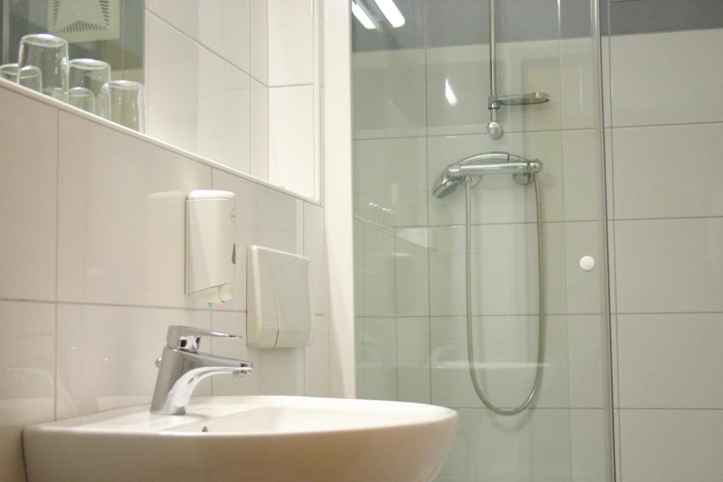 a bathroom with a sink and a shower at Hotel Korotan in Vienna