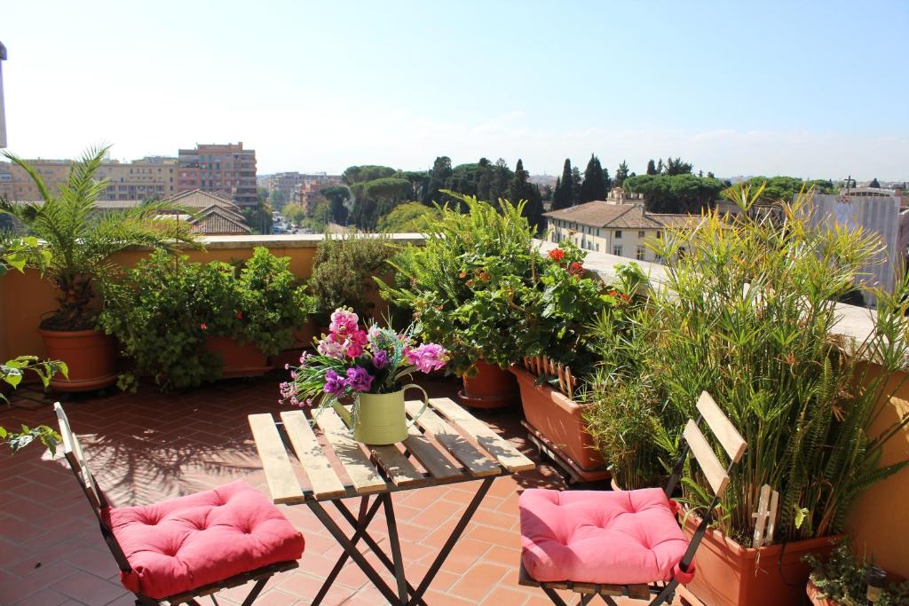 einen Balkon mit einem Tisch, Stühlen und Pflanzen in der Unterkunft Terrazza 29 Holiday Home in Rom