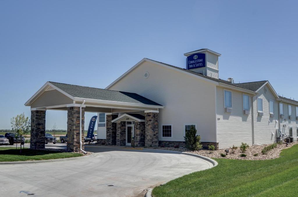 um grande edifício branco com uma torre de relógio no topo em Cobblestone Inn & Suites-Kersey em Kersey