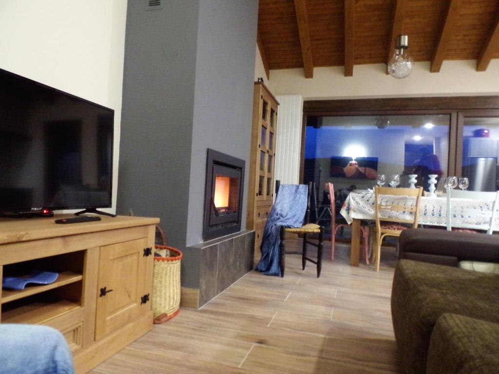 ein Wohnzimmer mit einem Flachbild-TV und einem Tisch in der Unterkunft PENDAN DE GREDOS in San Martín del Pimpollar