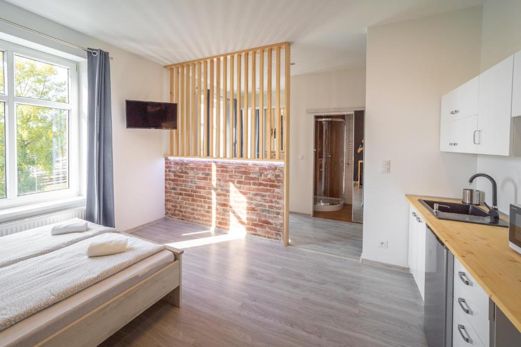 una cucina e un soggiorno con camino in mattoni di Black & White Vision Apartment - Centrum a Opole