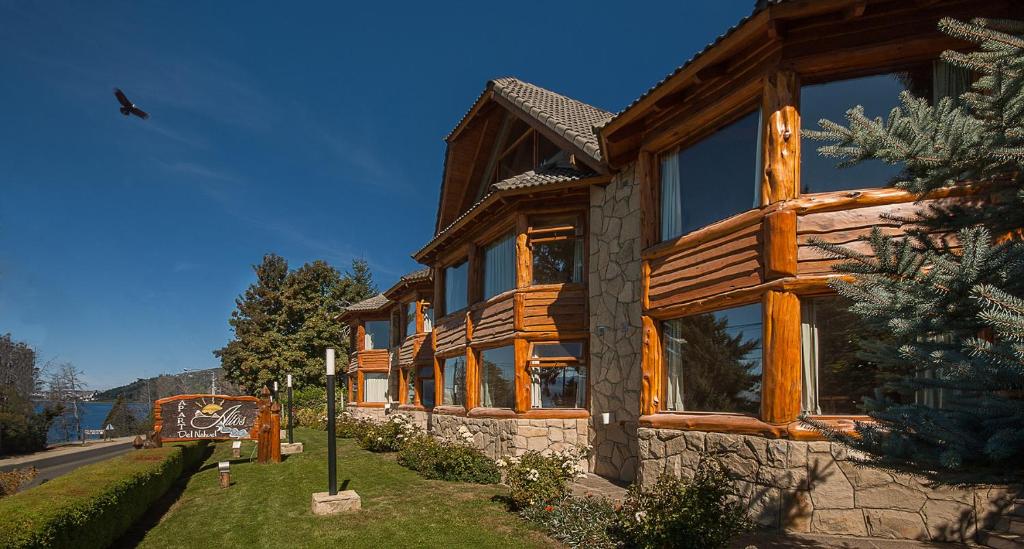 a wooden house with large windows on the side of it at Apart Altos Del Nahuel in San Carlos de Bariloche