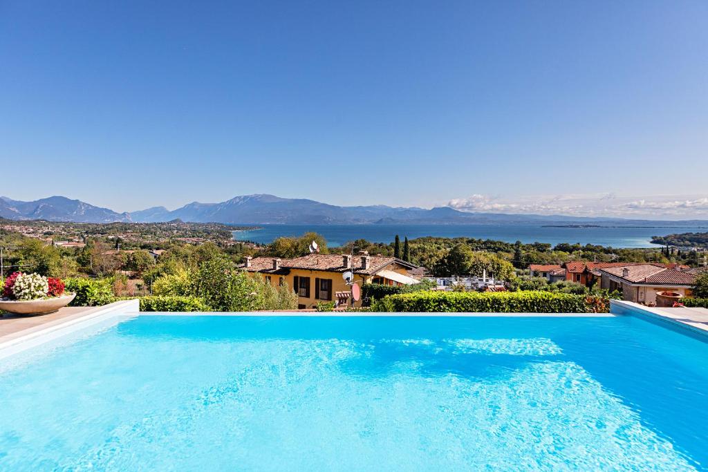 a large swimming pool with a view of the water at Villa Perla con piscina by Wonderful Italy in Barcuzzi