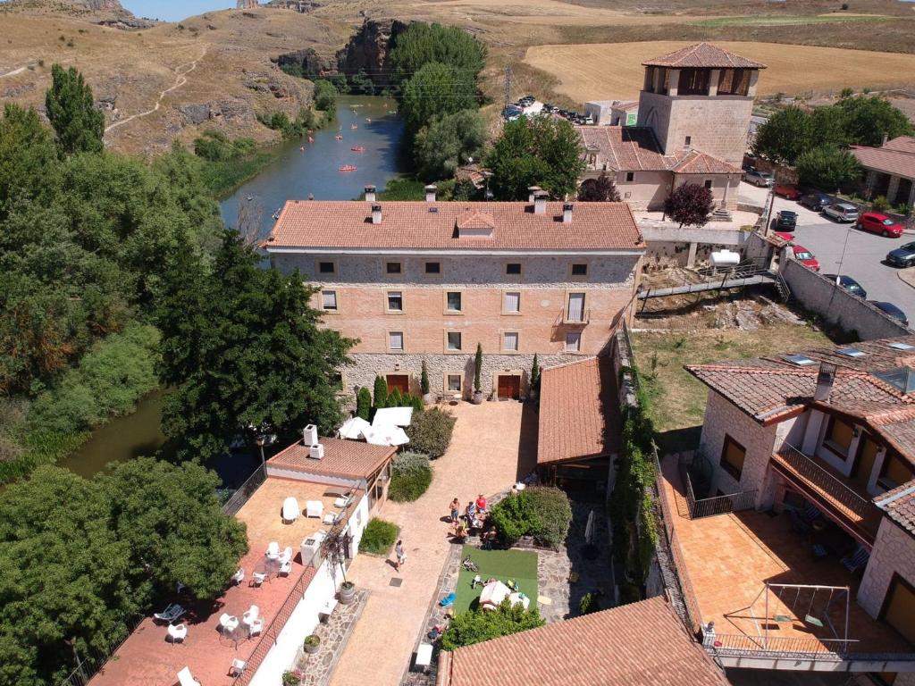 San Miguel de Bernúy的住宿－Molino Grande del Duratón，享有村庄和河流的空中景色