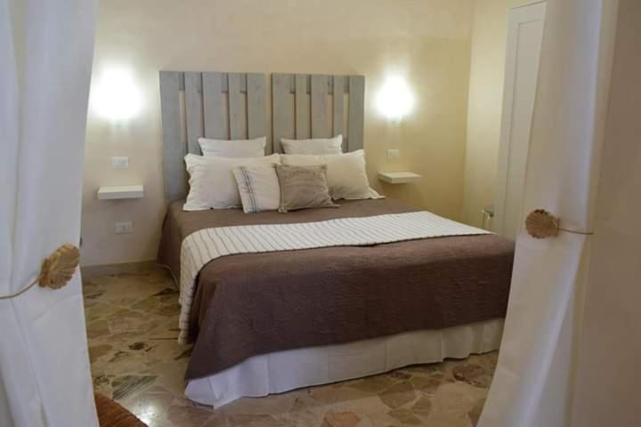 a bedroom with a large bed with white pillows at F&L house in Polignano a Mare