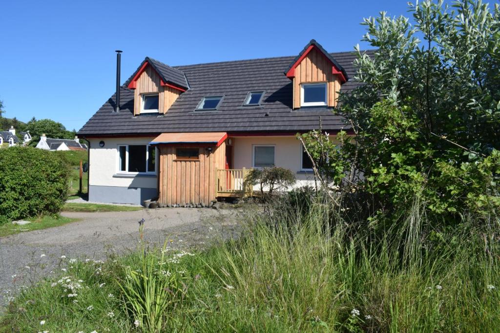 une maison avec un toit en gambrel dans l'établissement Skye Lodge Dunvegan Skye, à Dunvegan