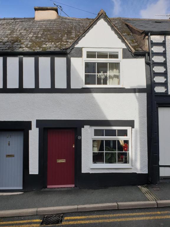 una casa blanca y roja con una puerta roja en 23 Riverside Cottage, Llangollen, en Llangollen