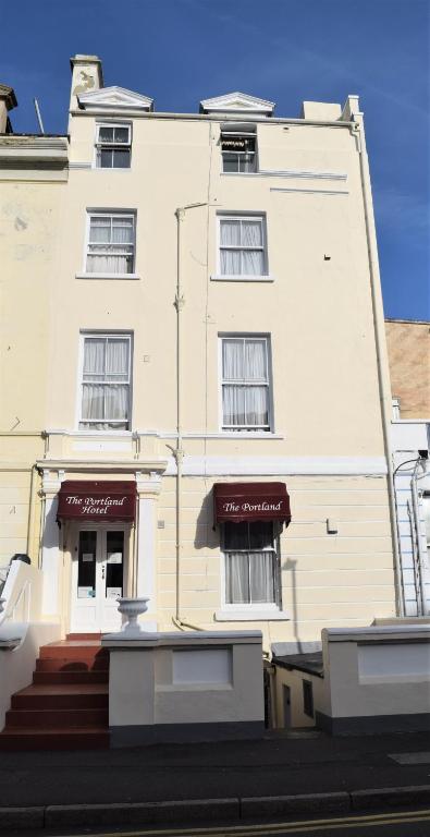 a large white building with two entrances to it at The Portland Hotel in Folkestone