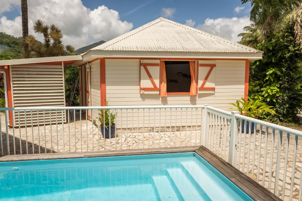 a house with a swimming pool in front of a house at Les jardins de Pointe Noire in Pointe-Noire