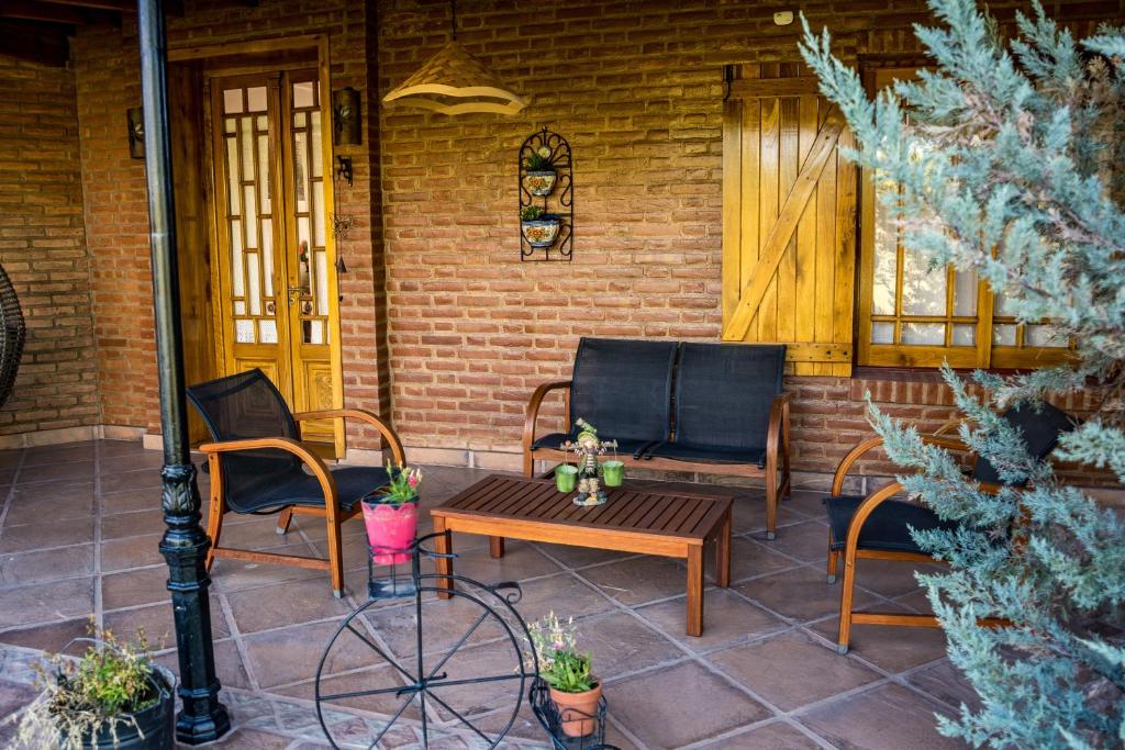 a patio with two chairs and a wooden table and chairs at Complejo Tierra Mia in Panaholma