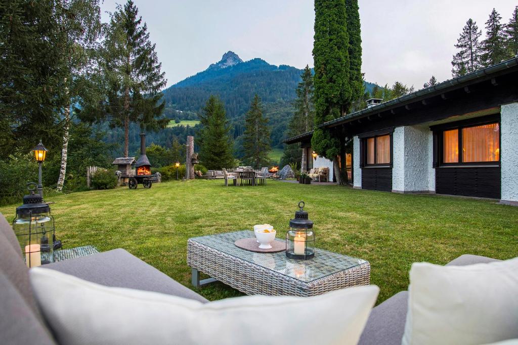 a patio with a table and chairs in a yard at Chalet Waldhaus Rappakopf in Tschagguns