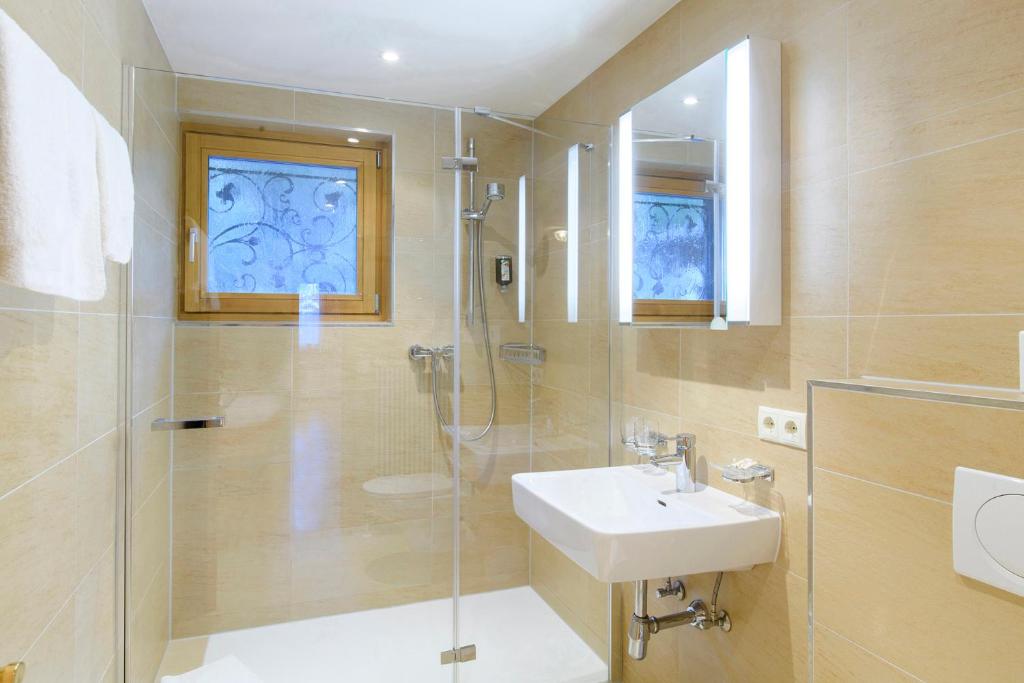 a bathroom with a shower and a sink and a glass shower at Chalet Waldhaus Rappakopf in Schruns