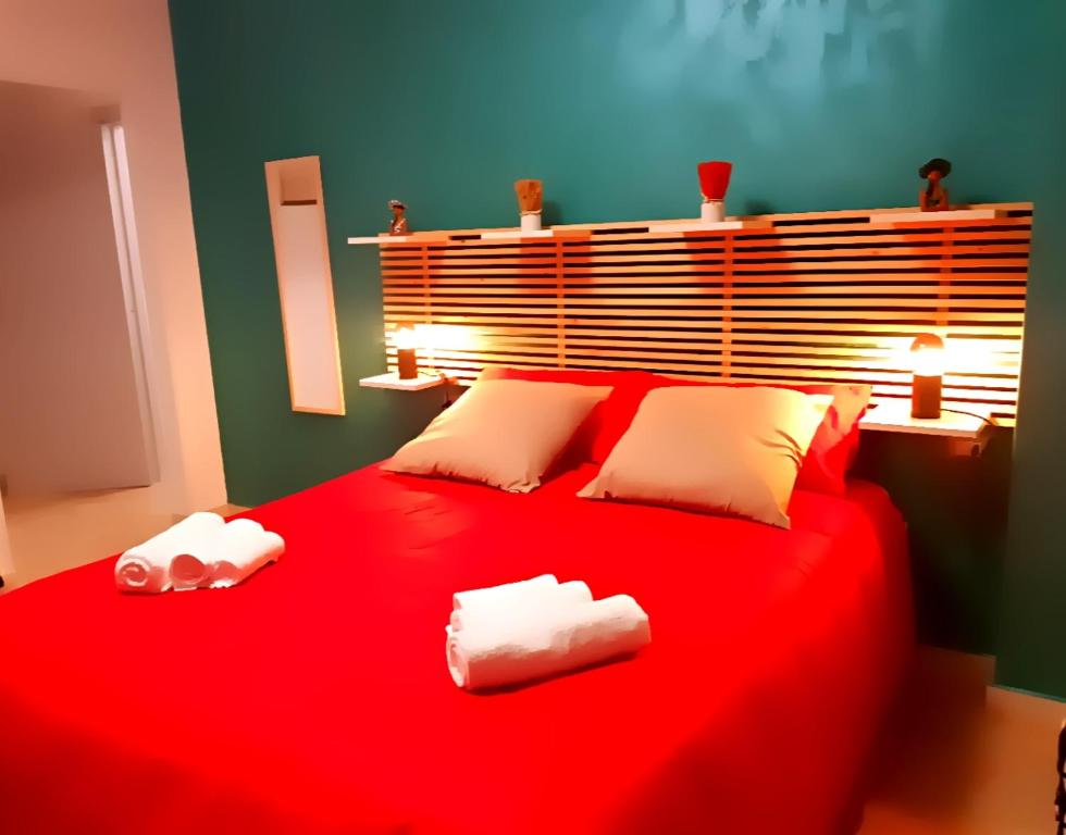 a bedroom with a red bed with two towels on it at Notti Rosa B&B in Melfi