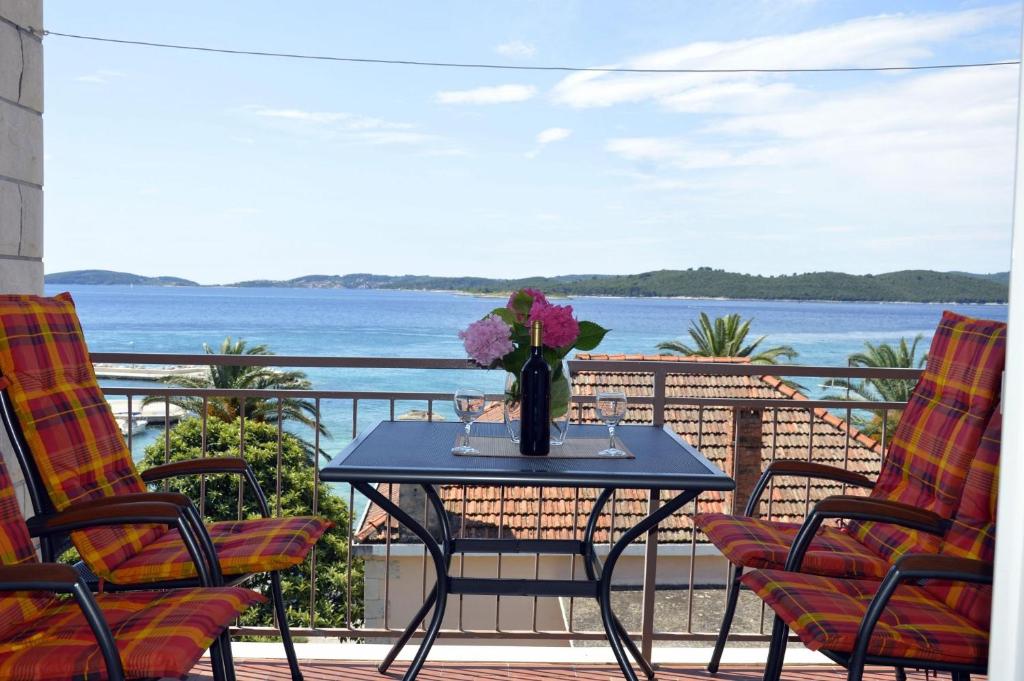 a table with a vase of flowers on a balcony at Apartments Zdravko - comfortable & close to the sea in Orebić