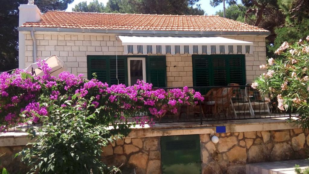 a house with purple flowers on a balcony at Holiday Home Dragan - 50m from sea in Splitska