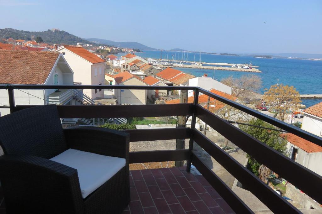 a balcony with a chair and a view of the water at Apartments Marin - 100m from beach in Tkon