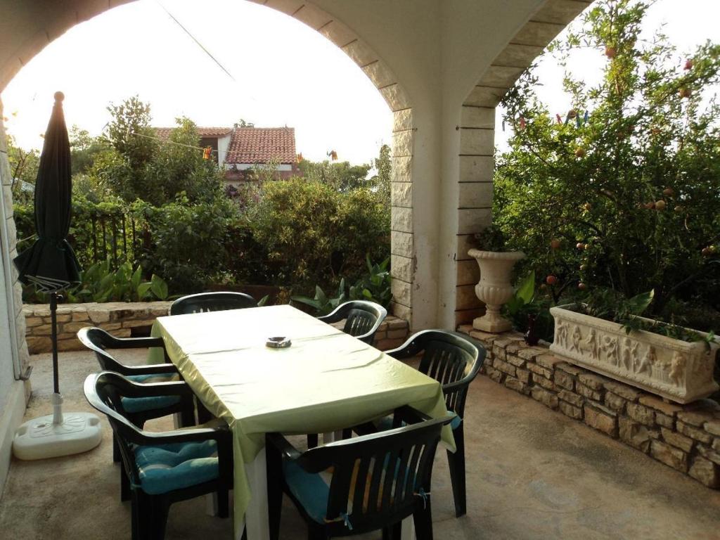 a table and chairs on a patio with an archway at Apartments Jere - with parking in Sutivan