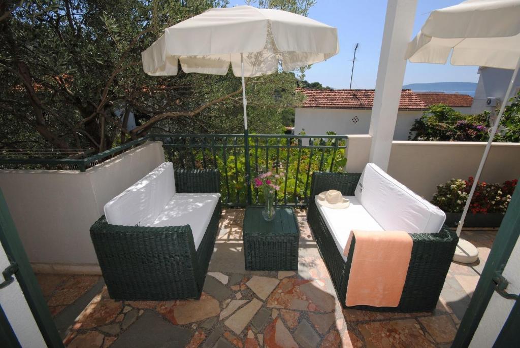 two chairs and an umbrella on a patio at Apartment Rina - 200 m from beach in Okrug Donji