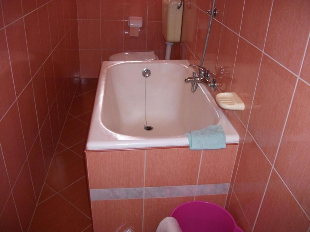 a bathroom with a sink in a tiled wall at Apartment Dusko - free parking in Gornji Karin