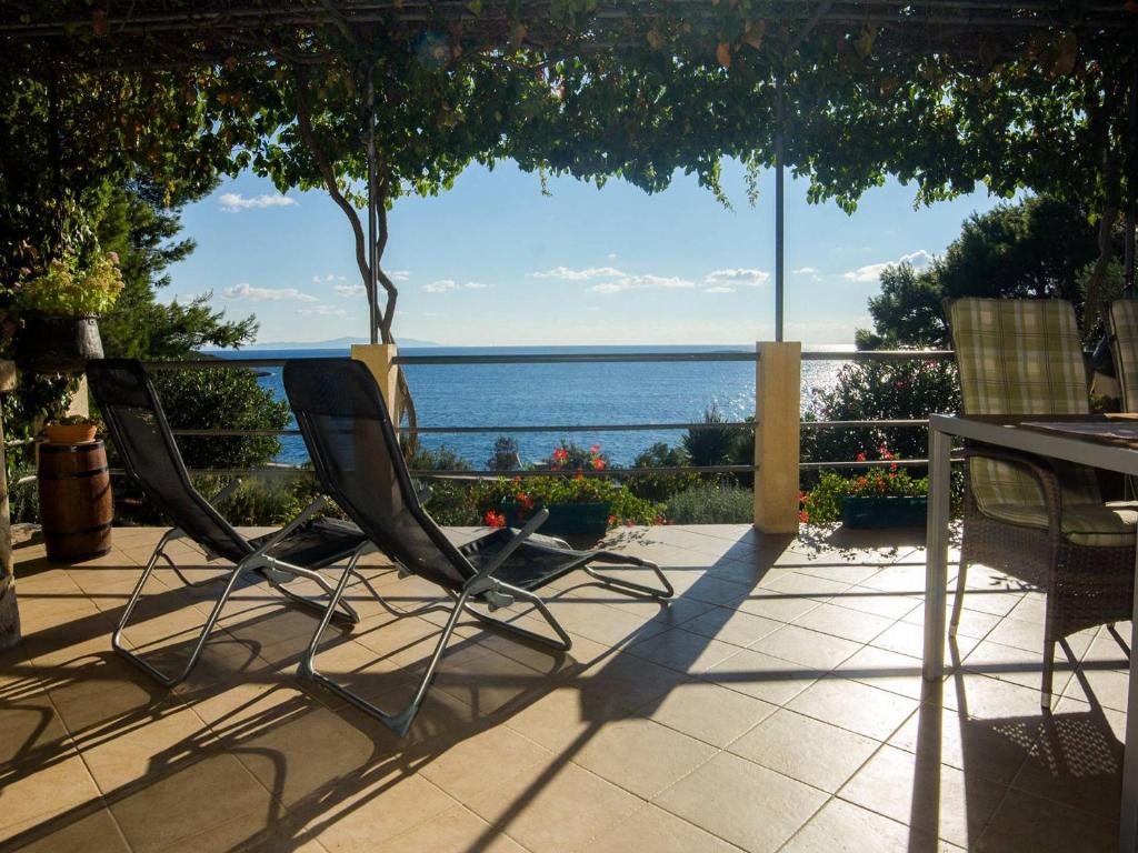 un patio con sillas, una mesa y el océano en Holiday home Ani - 30 m from beach, en Maslinica
