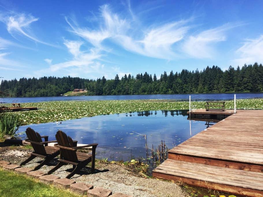 a bench sitting next to a lake with a dock at Lakeside Living Suite! Mt Rainier, Nwtrek, Jblm in Eatonville