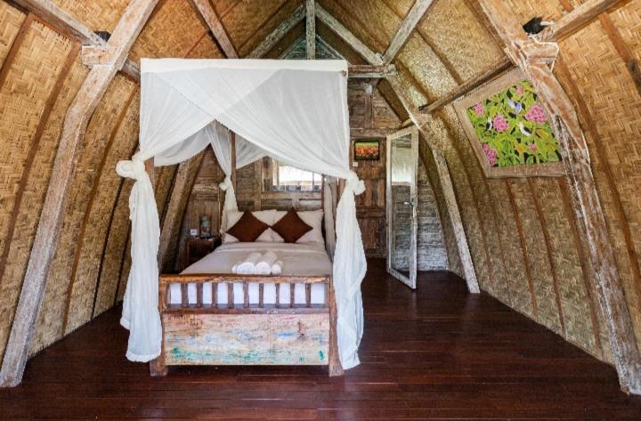 a bedroom with a canopy bed in a room at Royal JJ Ubud Resort & Spa in Ubud