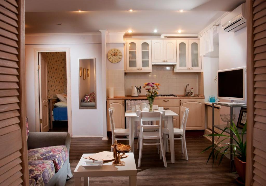 a kitchen and living room with a table and chairs at Klarabara Apartment in Odesa