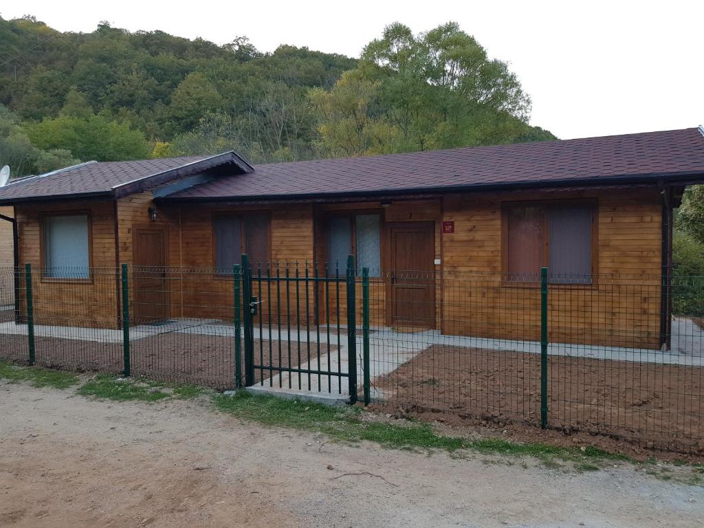 a house with a fence in front of it at ЕКО БУНГАЛА in Trŭn