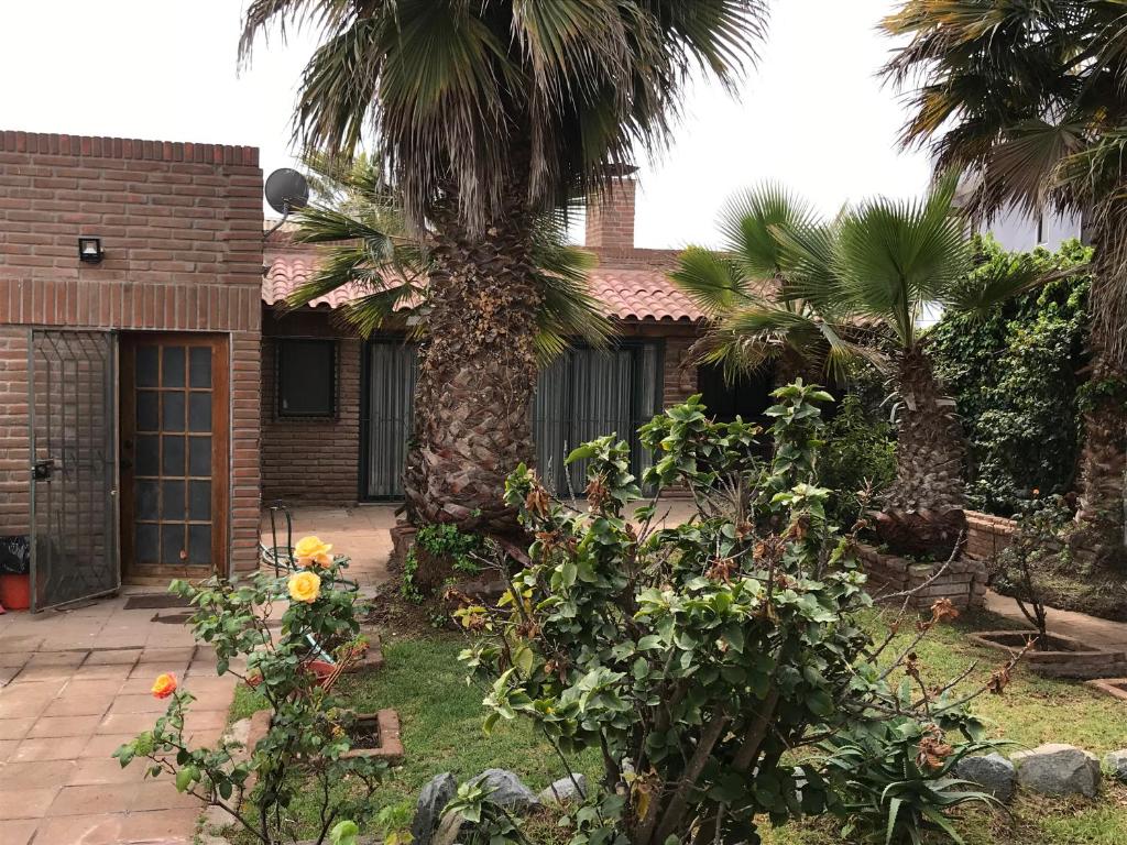 una casa con palme di fronte a un cortile di Linda Casa en Barrio Residencial la Herradura Oriente a 5 min playa a Coquimbo