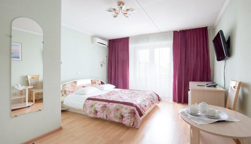 um quarto de hotel com uma cama e um espelho em Annushka Hotel em São Petersburgo