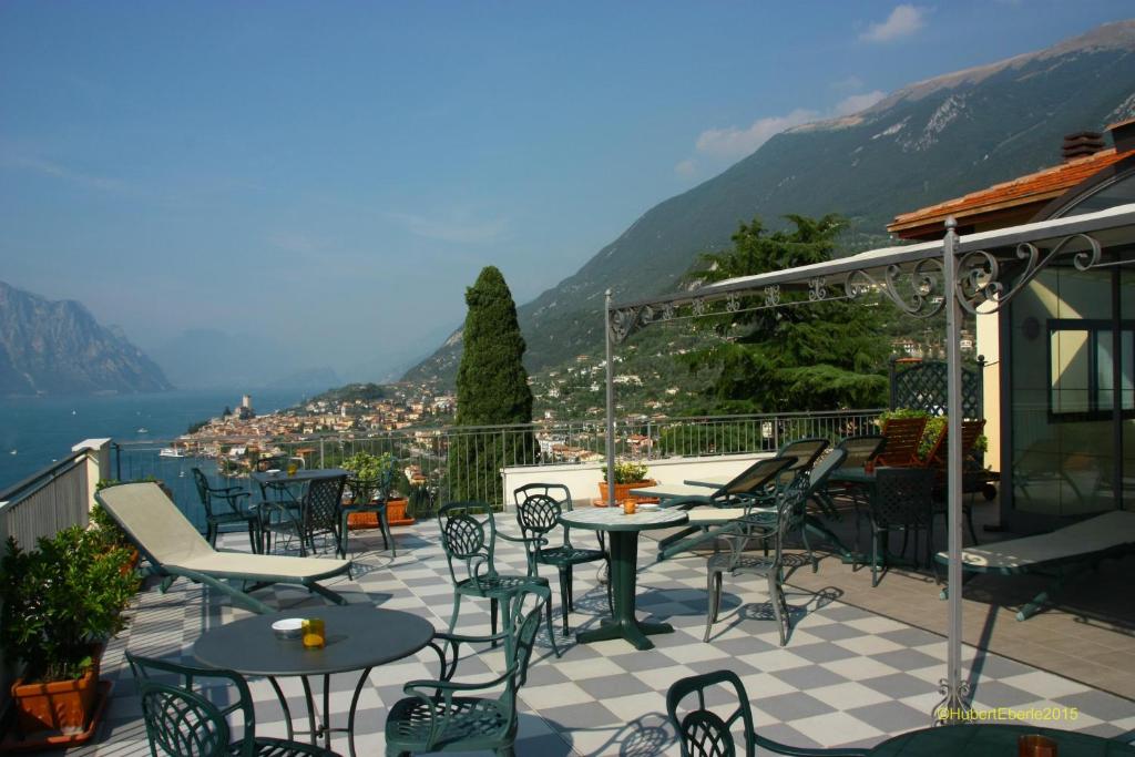 a patio with tables and chairs and a view of a city at Casa Antonelli in Malcesine