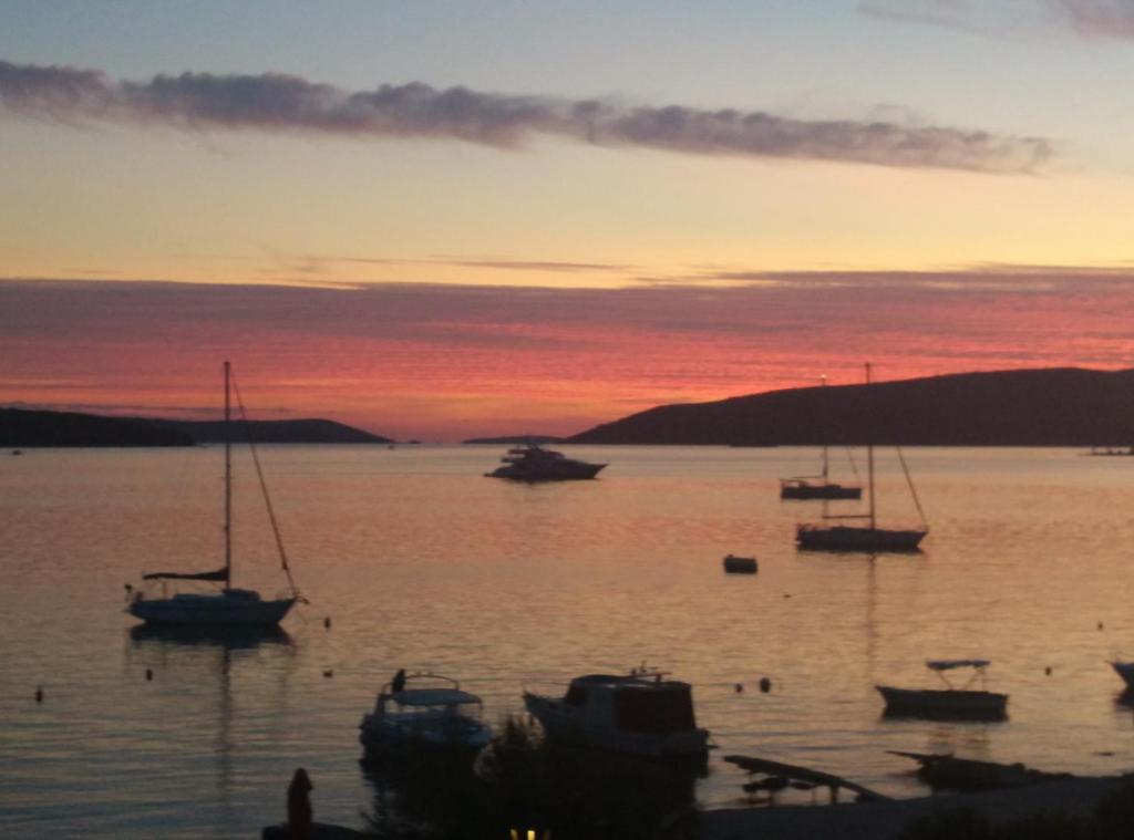 a group of boats in the water at sunset at Apartments Gina in Trogir