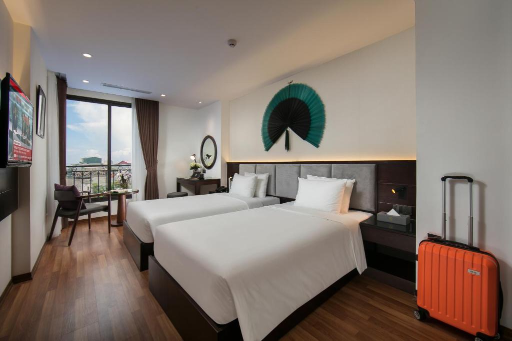 A bed or beds in a room at Hanoi Fiesta Hotel & Spa