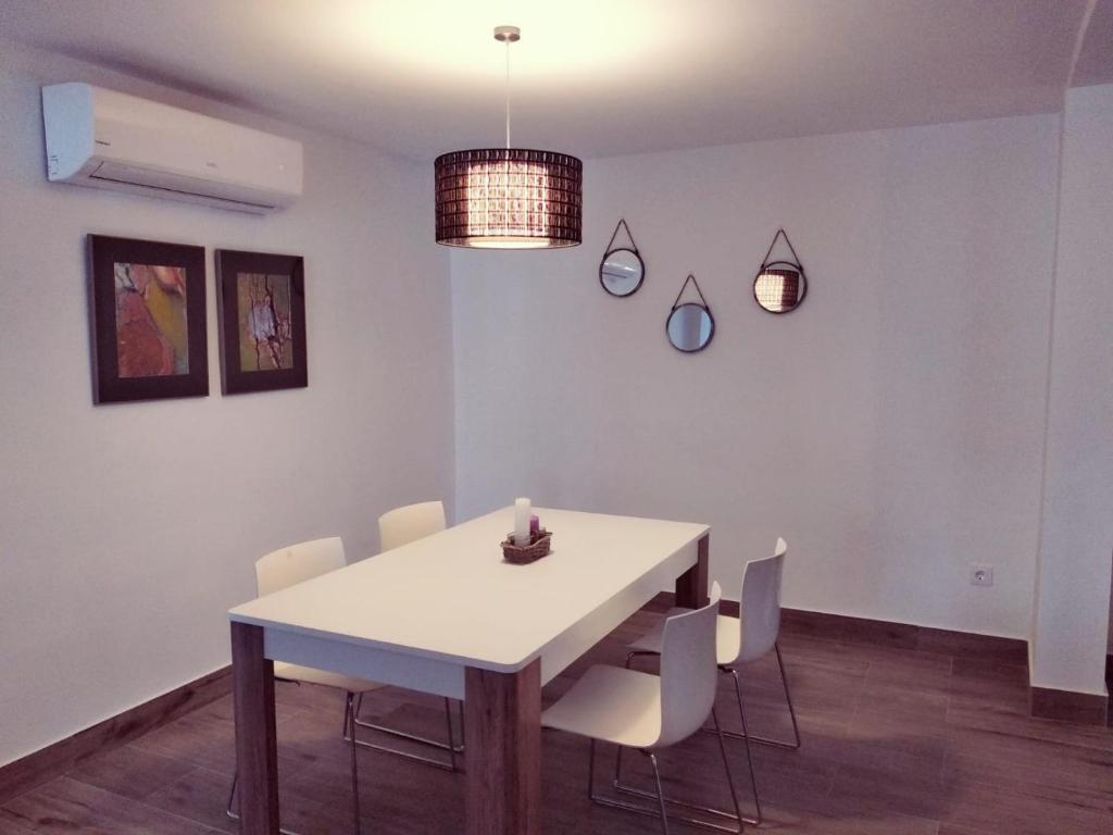 a dining room with a white table and chairs at Alojamientos 4nudos in San José